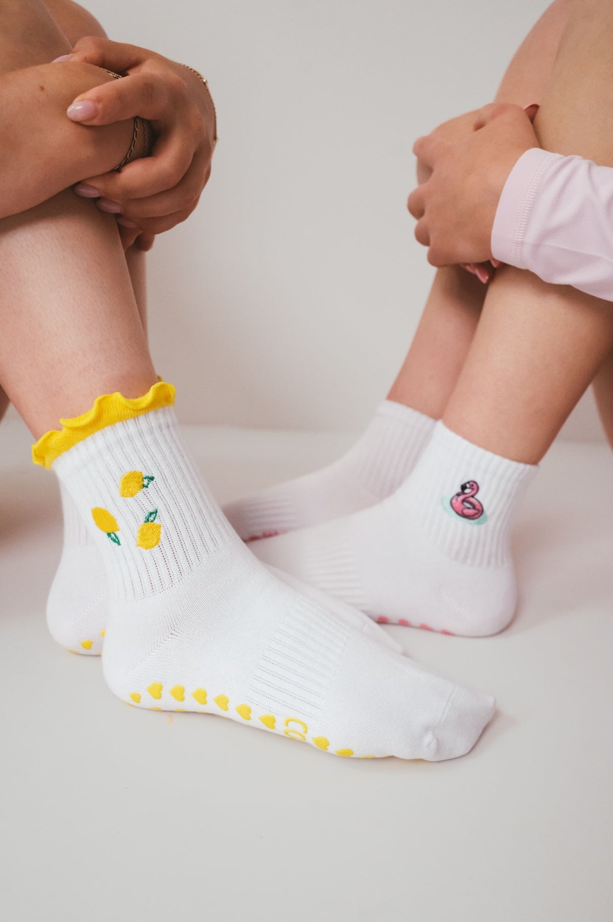 Flamingo Floatie Sock with pink heart grips, worn next to the Lemon Sock
